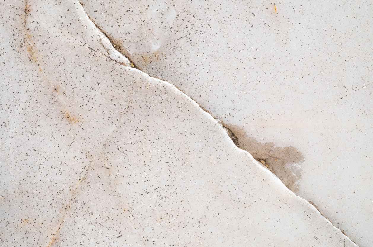 Closeup of a slab leak on a marble floor